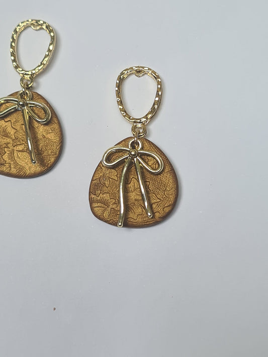Pendientes Dorados con Dije Texturizado y Lazo — Elegancia Artesanal